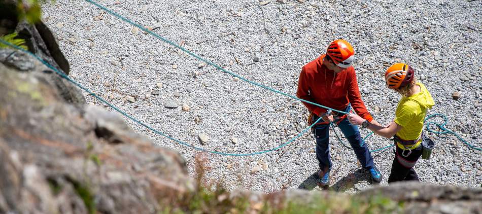Un adulte fait de l'escalade avec un guide au site des Gaillands à Chamonix